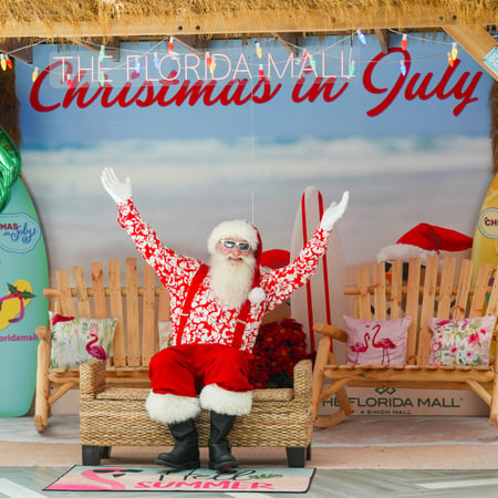 Santa with a Christmas in July background.