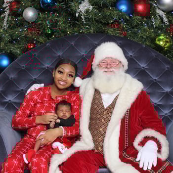 Mom and her newborn sitting with Santa.