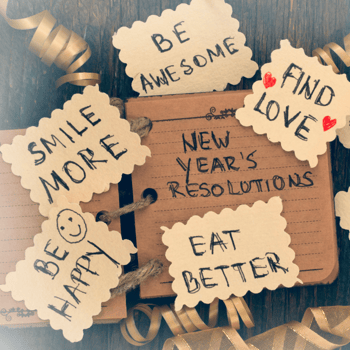 A paper with "New Years Resolutions" written on it surrounded by notes with affirmations that say things like "Be Awesome" and "Eat Better"