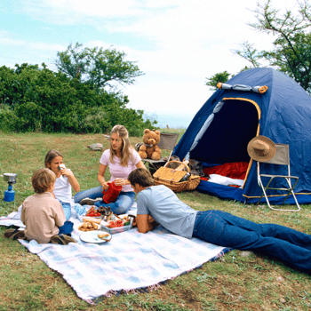 A family having a picnic at their camp site.