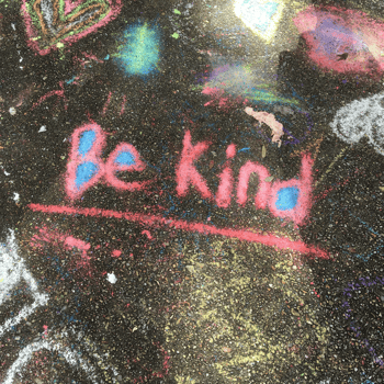 Be Kind written in chalk on a sidewalk.