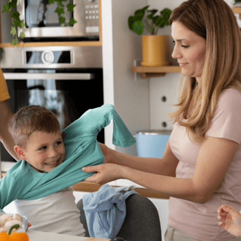 A mom helping her son get dressed.