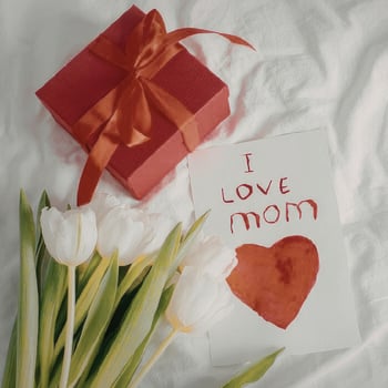 An "I love Mom" card with tulips and a present.