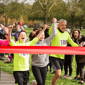 A family running across a finish line of a race.