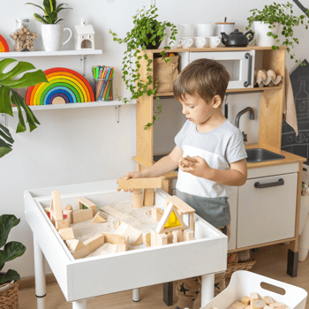 A little boy playing with blocks in a sensory bin.