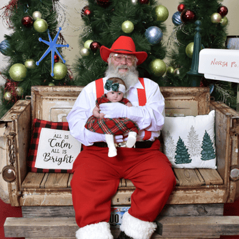 A baby girl with Cowboy Claus.