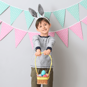 A little boy holding an Easter Basket filled with eggs.