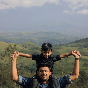 A dad and his son in front of a mountain after hiking.