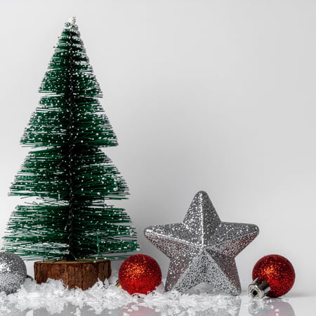 A little tabletop Christmas tree with ornaments, fake snow, and a glitter star.
