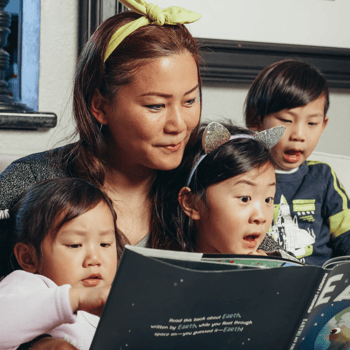 A mom reading with her three kids.