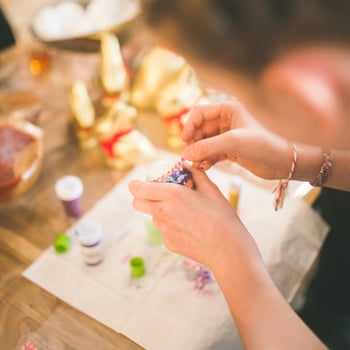 A girl putting gems on an Easter egg.