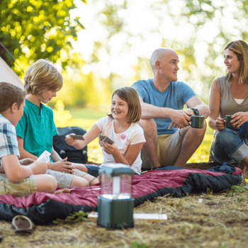 A family playing card games at their camp site enjoying time together.