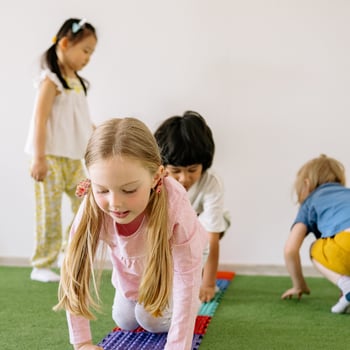 Kids doing an indoor obstacle course.