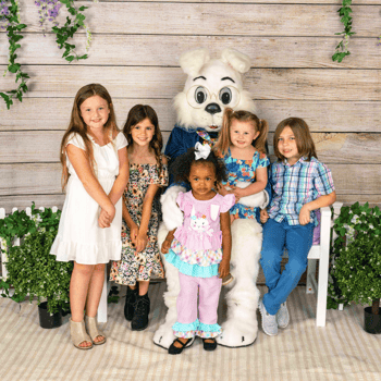A bunch of little kids with the Easter bunny in coordinated color outfits.