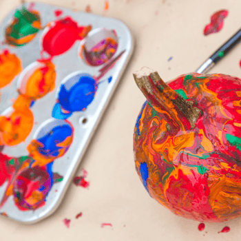 A pumpkin covered in various color paint.