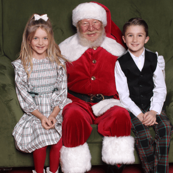 A little boy and girl sitting with Santa.