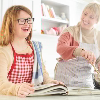 A mother and daughter cooking in the kitchen together.