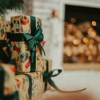 A pile of presents under a tree.
