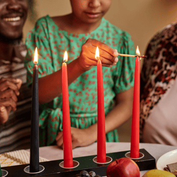 A family celebrating Kwanza with a kinara.