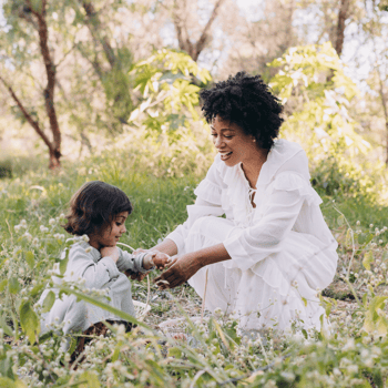 A mother and daughter putting Easter eggs in a basket.