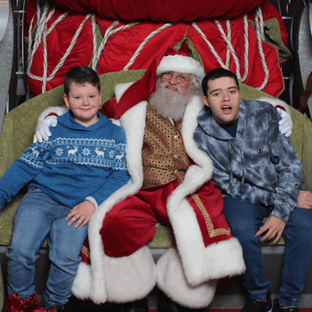 Two brothers sitting with Santa.