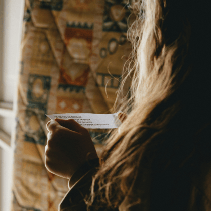 A young girl reading a scavenger hunt clue.