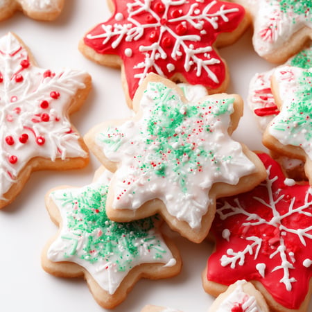 Snowflake shaped sugar cookies with red, white, and green icing and sprinkles.