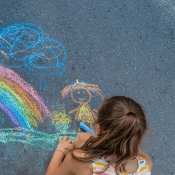 A little girl playing with sidewalk chalk.