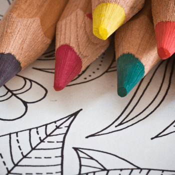 Colored pencils lying on top of a coloring page.