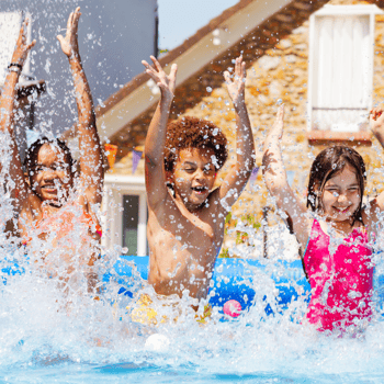 Kids splashing in a backyard pool.