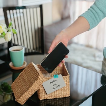 A mom putting her phone in a box.