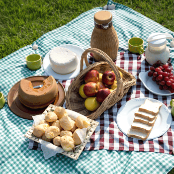 A picnic with fruit, bread, and angel food cake.
