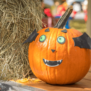 A pumpkin with a face made out of paper glued on.