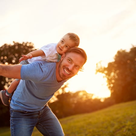 A dad with his son playing airplane.
