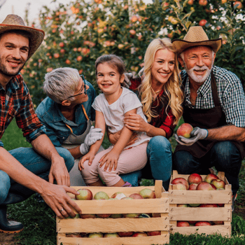 A family together in behind the baskets of apples they picked.