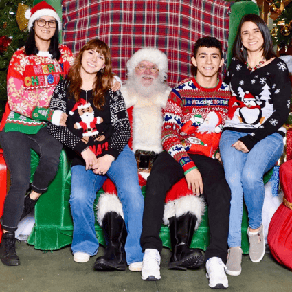 Group of friends wearing ugly Christmas sweaters with Santa.