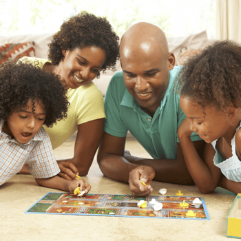 A family playing a board game together on the floor.