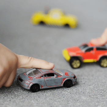 Tiny toy cars with little kids playing with them.