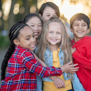 Kids hugging each other laughing.
