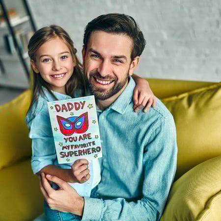 A dad and daughter with a Father's Day card.