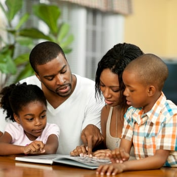 A family looking at a book together.
