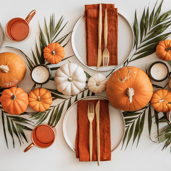 Thanksgiving table decor with pumpkins and leaves.