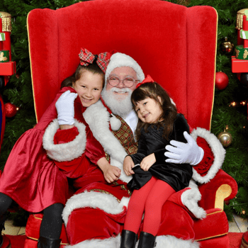 Two girls sitting with Santa