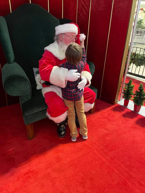 Little boy with autism meets Santa and tugs at his hat