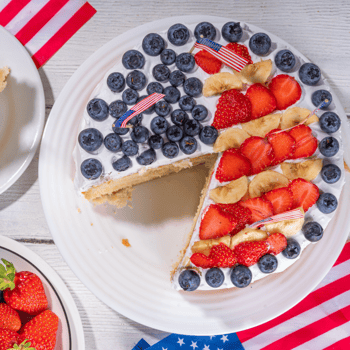 A berry shortcake with blue berries, strawberries, and bananas laid to look like the American Flag.