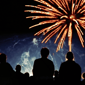 Silhouettes of people watching fireworks.