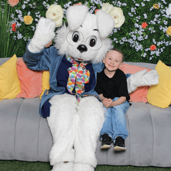 A little boy sitting with the Easter Bunny.