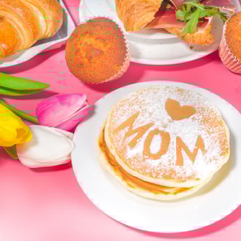 Pancakes with Mom written on them in powdered sugar.