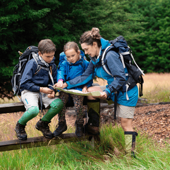 A mom and her two kids looking at a map of a national park.