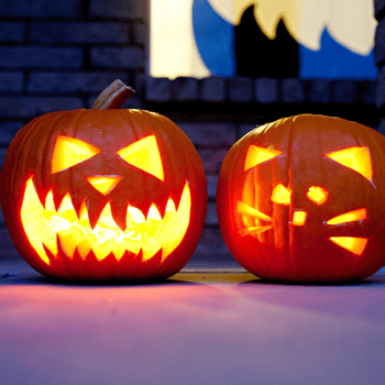 Two pumpkins carved into a face and a cat.